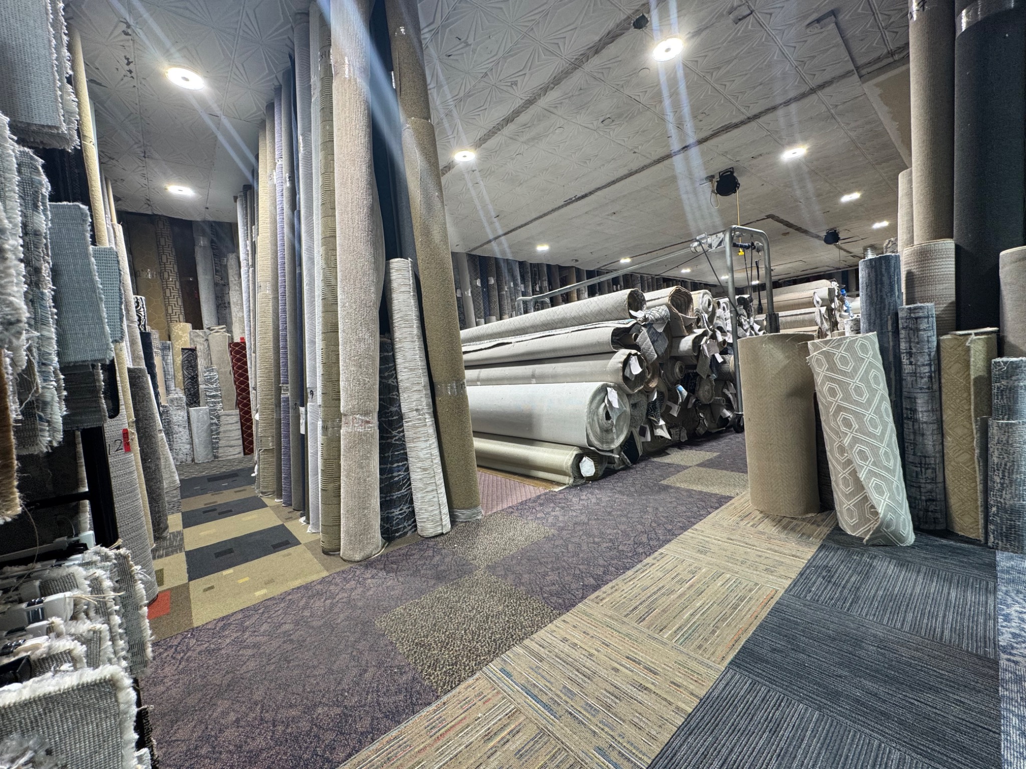 Carpet rolls and material inventory inside the Carpet and Design showroom and warehouse